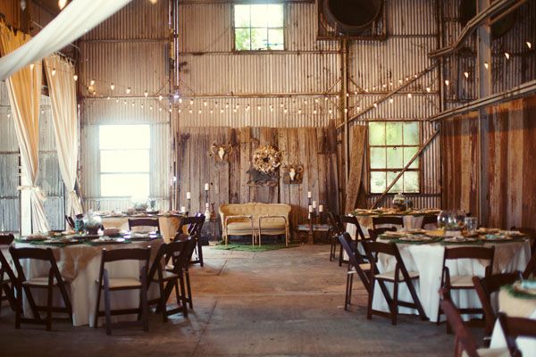 Loving the strings of lights and round tables with white cloths against the wooden walls.